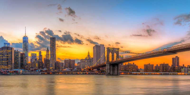 Brooklyn bridge and downtown New York City in beautiful sunset.